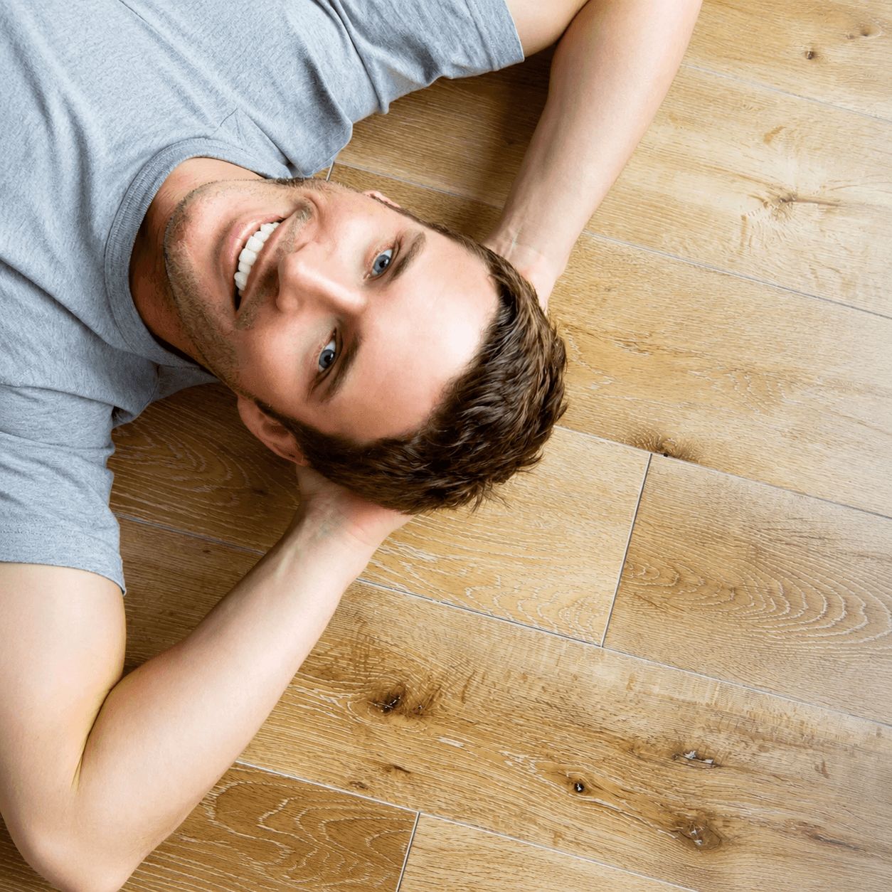 Happy customer lying on a beautifully restored wooden floor